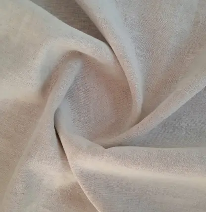 Zbliżenie na miękko ułożoną, jasną tkaninę
